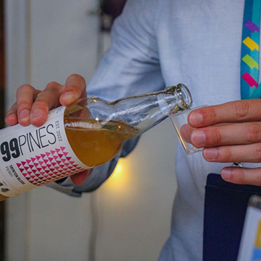 Photo of a man pouring 99 Pines Perry into a small sampling glass