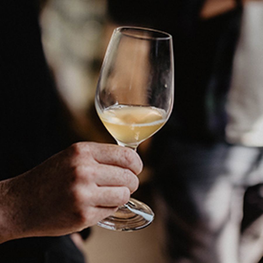 Photo of someone's hand holding cider in a cider glass; ©2021, Amelia Claudia Photography