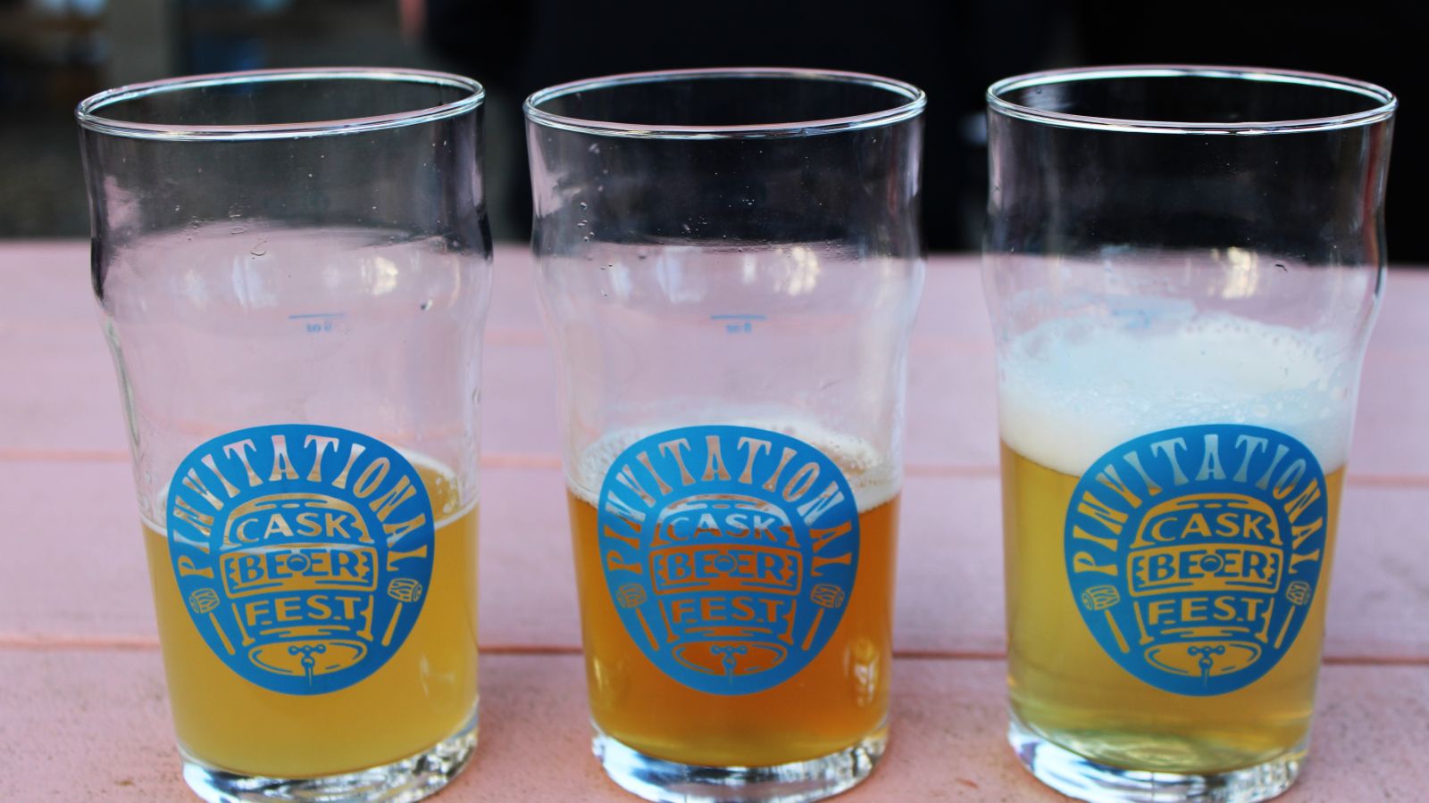 Photo of three half filled pint glasses, with Invitational logo on the side © 2024, Justin Brummer