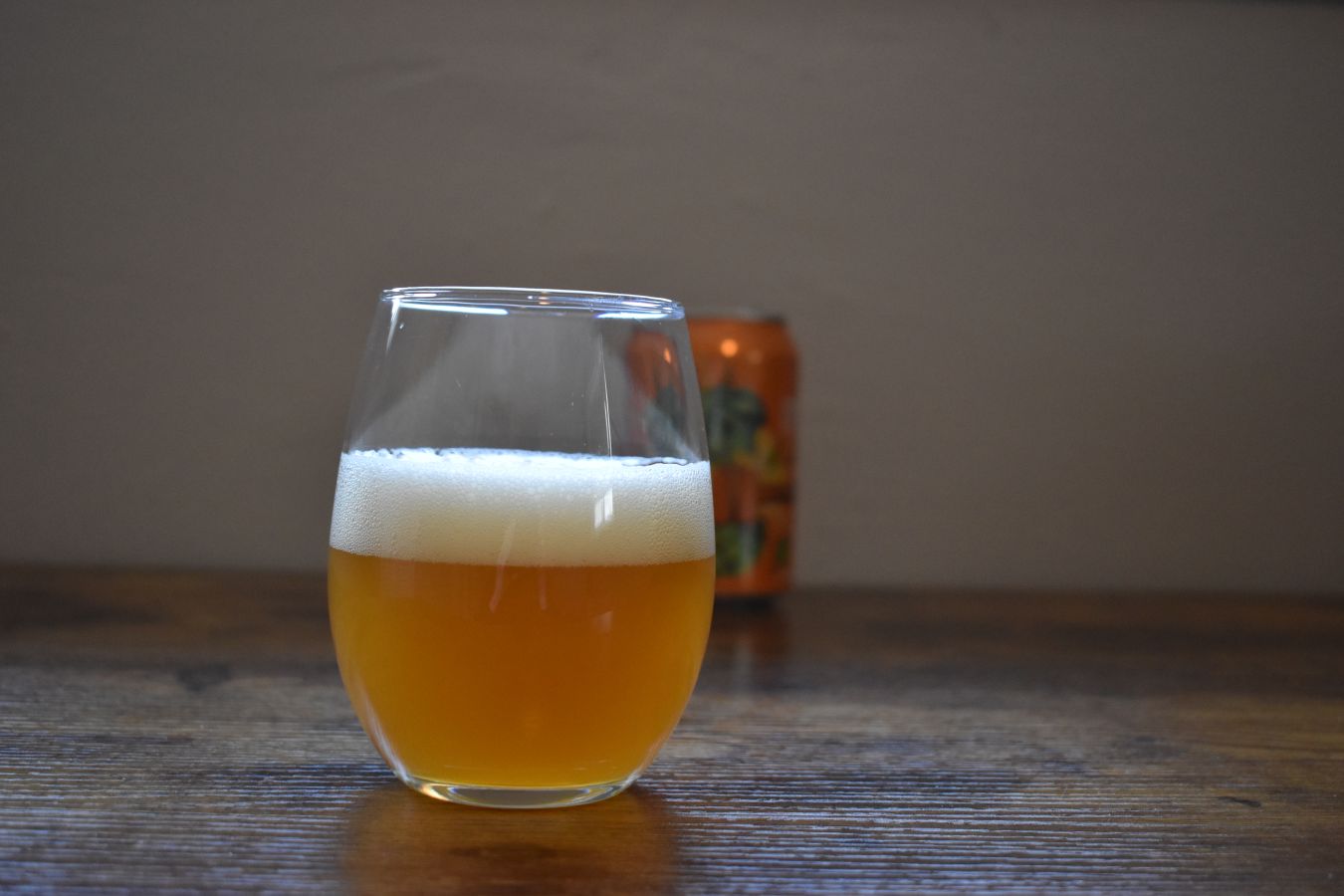 Photo of a small glass of New England IPA, with a can in the background; ©2022, Hollie Stephens Photography