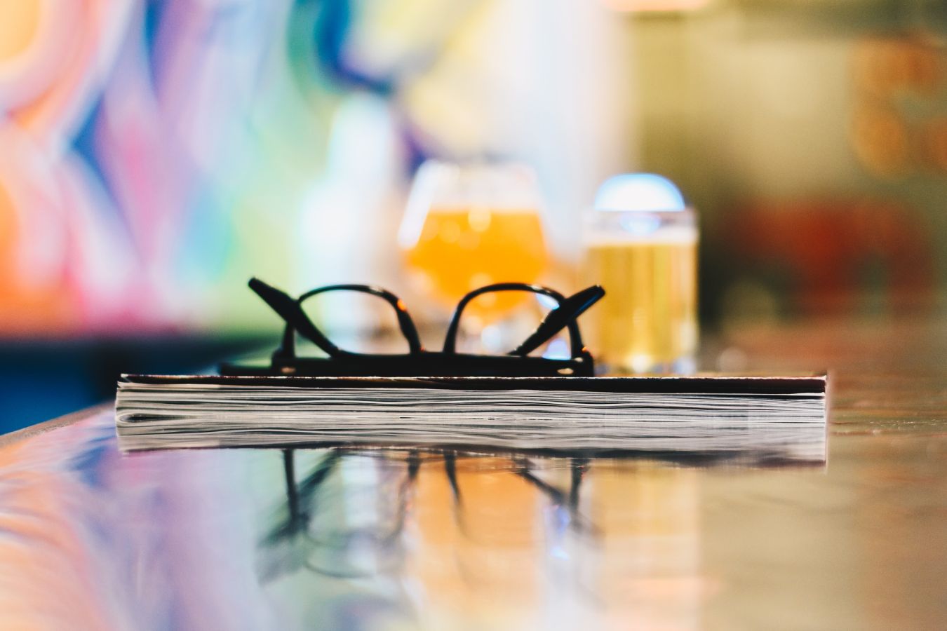 Photo of a pair of spectacles and a notebook, in front of a couple of pints of beer ©2018, Robbie Noble Photography @ Unsplash